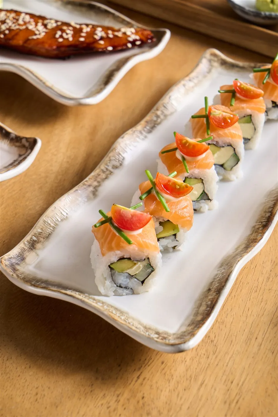 Sushi roll salmon di piring keramik putih