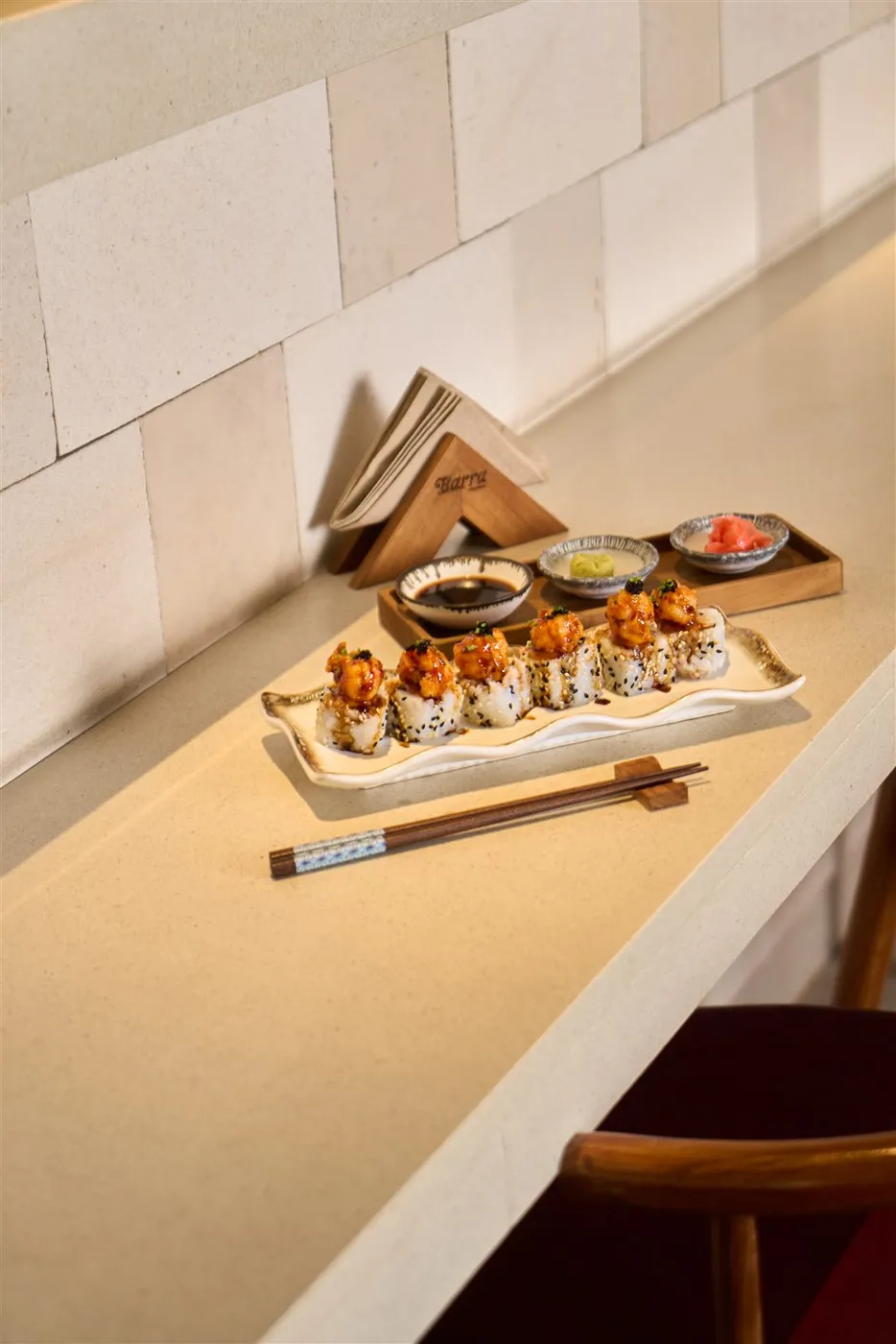 Sushi roll di meja bar dengan saus