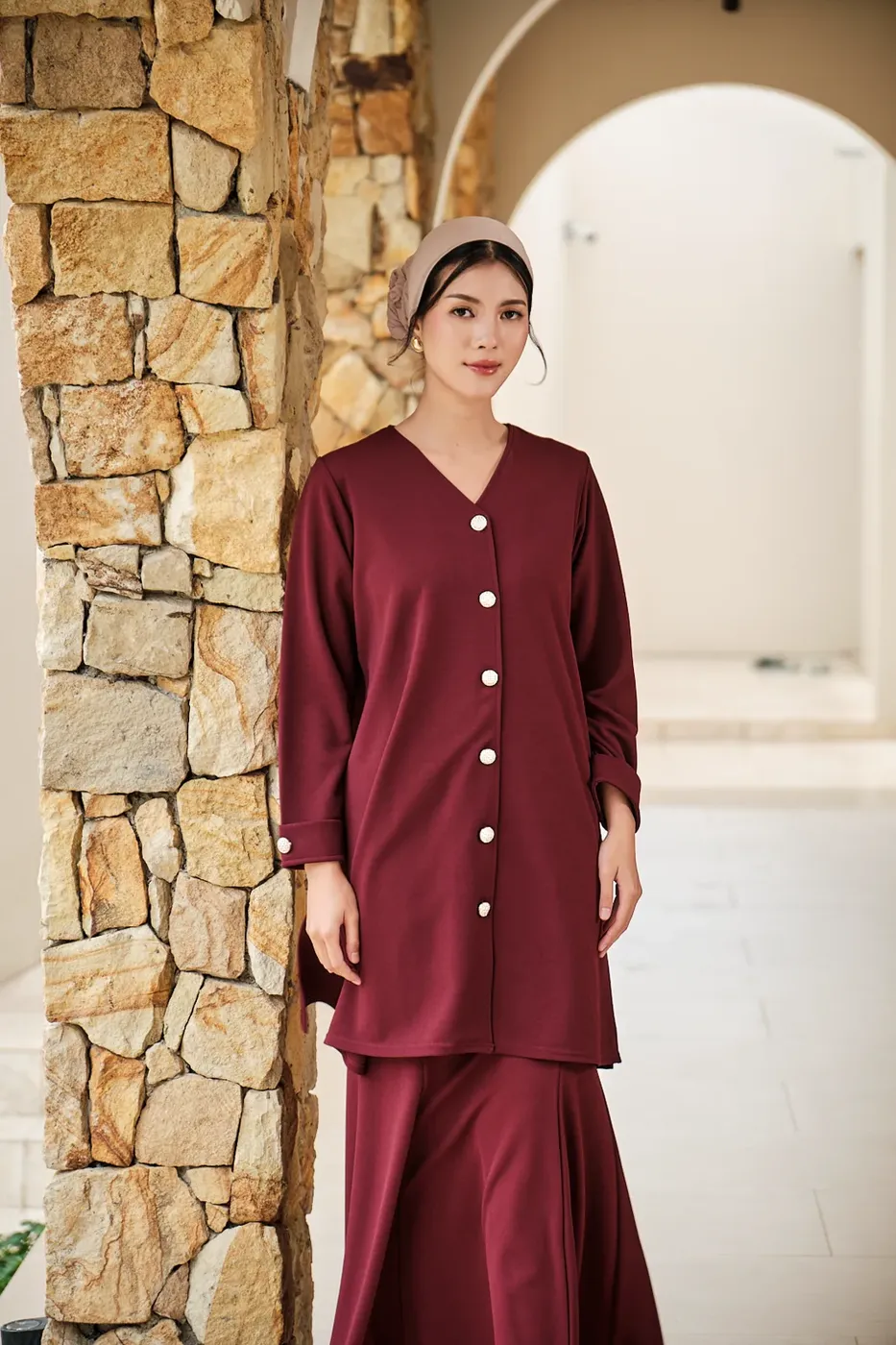 Model dengan setelan merah marun