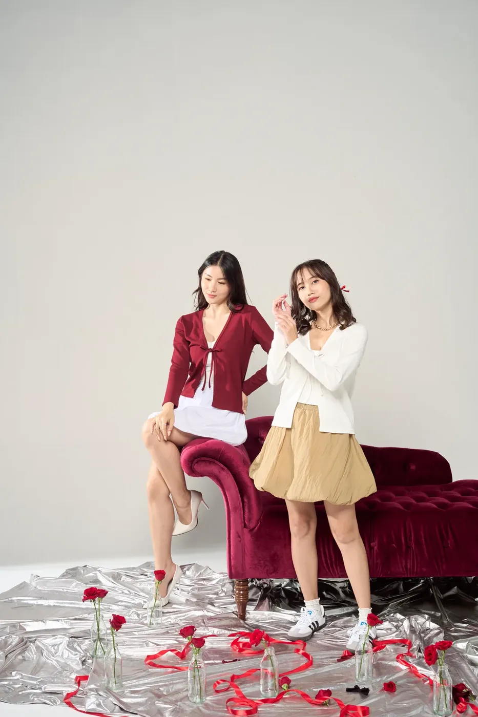 Dua model di depan sofa merah